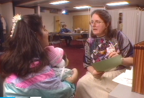 Dr. Wexler speaking with a woman and her infant in a clinical setting.